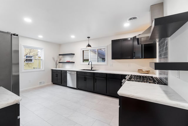 kitchen featuring light stone counters, stainless steel appliances, exhaust hood, sink, and hanging light fixtures