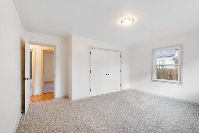 unfurnished bedroom with a closet and light colored carpet