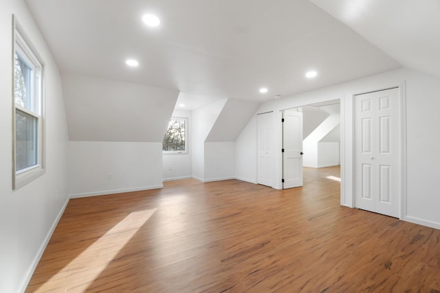 additional living space featuring light hardwood / wood-style floors and lofted ceiling