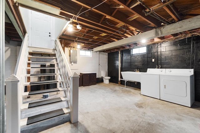 basement featuring electric panel, sink, and independent washer and dryer