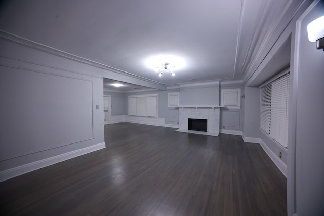 unfurnished living room featuring a tile fireplace, dark hardwood / wood-style floors, and ornamental molding