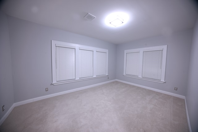 unfurnished room featuring light colored carpet