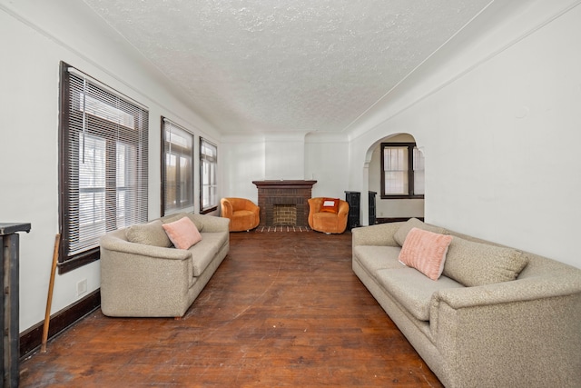 living room featuring a textured ceiling and dark wood-type flooring