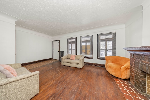 living room featuring a textured ceiling, a wealth of natural light, a fireplace, and dark hardwood / wood-style floors