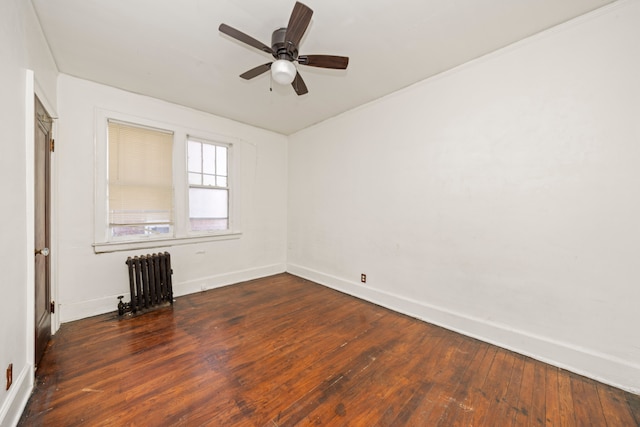 spare room with ceiling fan, radiator heating unit, and dark wood-type flooring