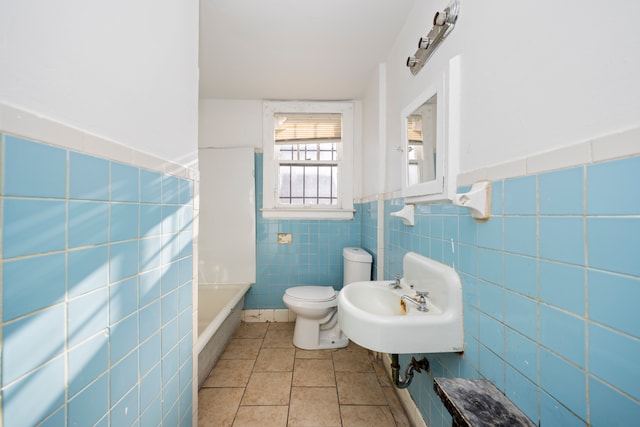 bathroom with sink, a bath, tile walls, tile patterned flooring, and toilet