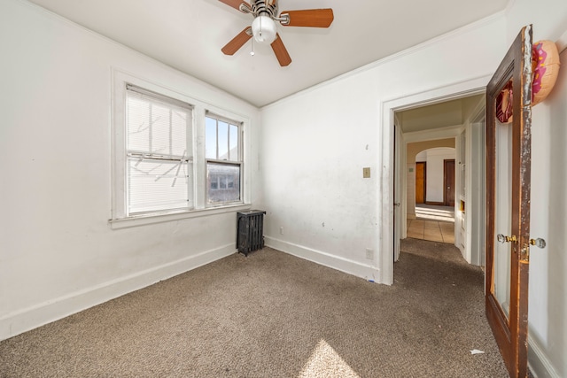 carpeted spare room with ceiling fan and crown molding