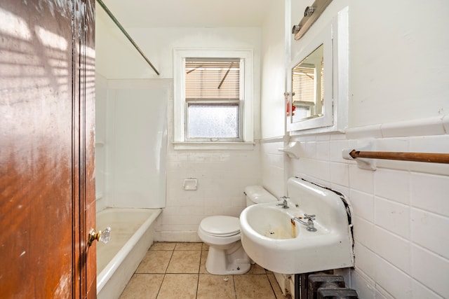 full bathroom with sink, shower / washtub combination, tile patterned flooring, toilet, and tile walls