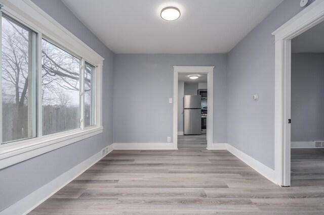 unfurnished room with light wood-type flooring