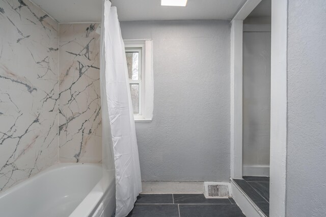 bathroom featuring tile patterned flooring and shower / bathtub combination with curtain