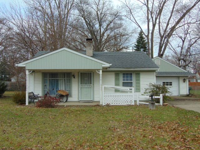 view of front facade featuring a front lawn, a porch, and a garage