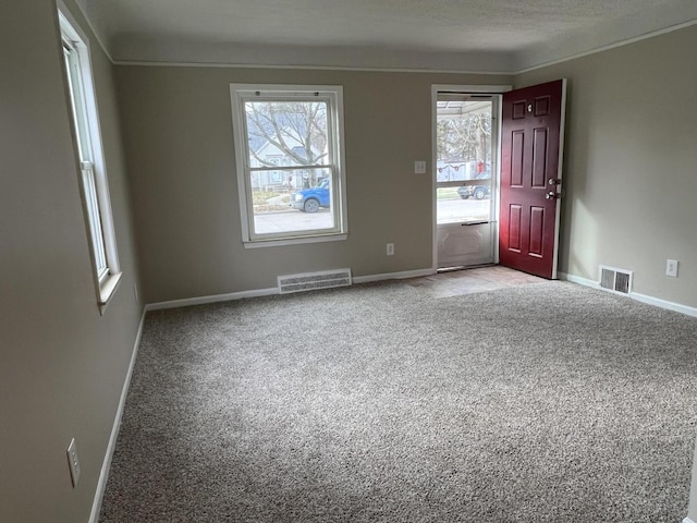 unfurnished room featuring light colored carpet and a textured ceiling