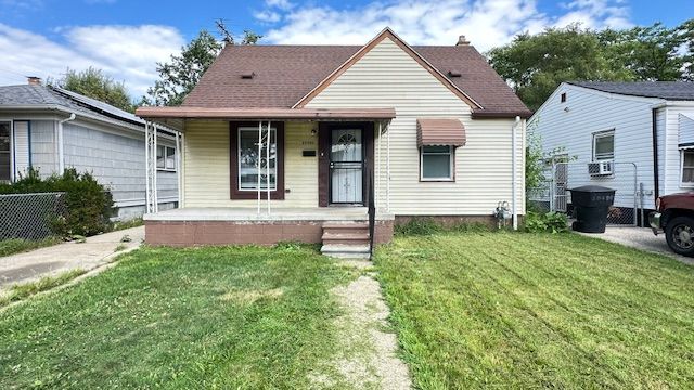 bungalow featuring a porch and a front lawn