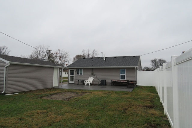 rear view of property featuring central air condition unit, a patio area, and a lawn