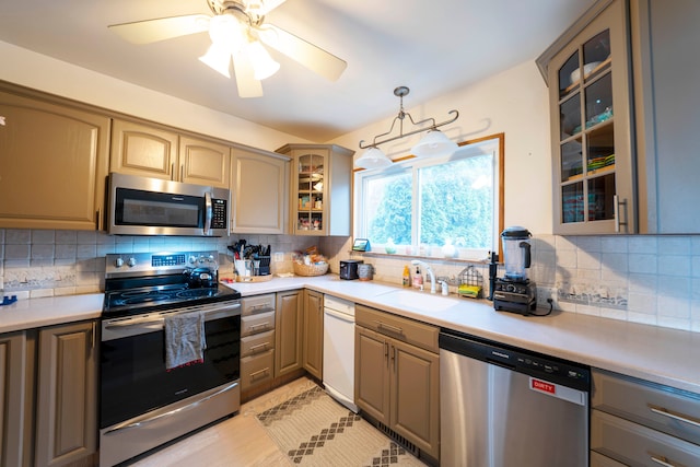 kitchen featuring stainless steel appliances, sink, decorative light fixtures, and decorative backsplash