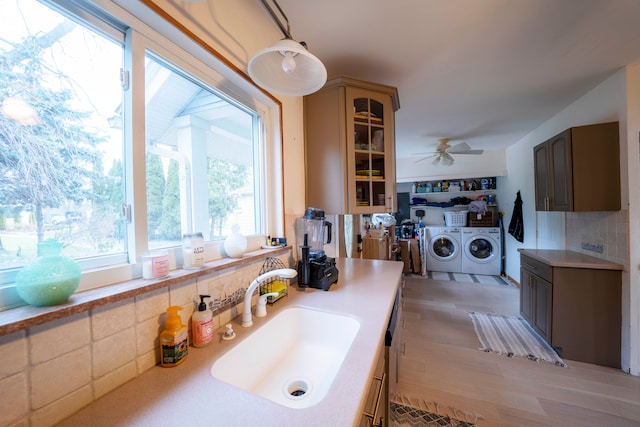 kitchen with separate washer and dryer, sink, light hardwood / wood-style floors, and ceiling fan