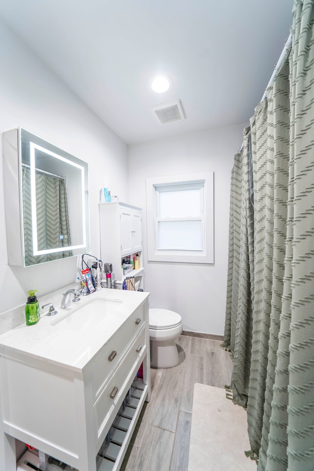 bathroom with vanity, hardwood / wood-style flooring, and toilet