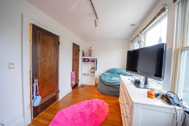 bedroom featuring light hardwood / wood-style flooring and track lighting