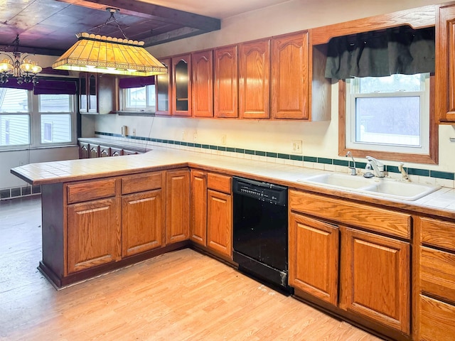 kitchen featuring plenty of natural light, sink, black dishwasher, and a chandelier