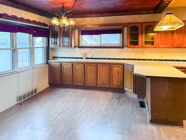 kitchen with pendant lighting, light hardwood / wood-style floors, an inviting chandelier, and wooden ceiling