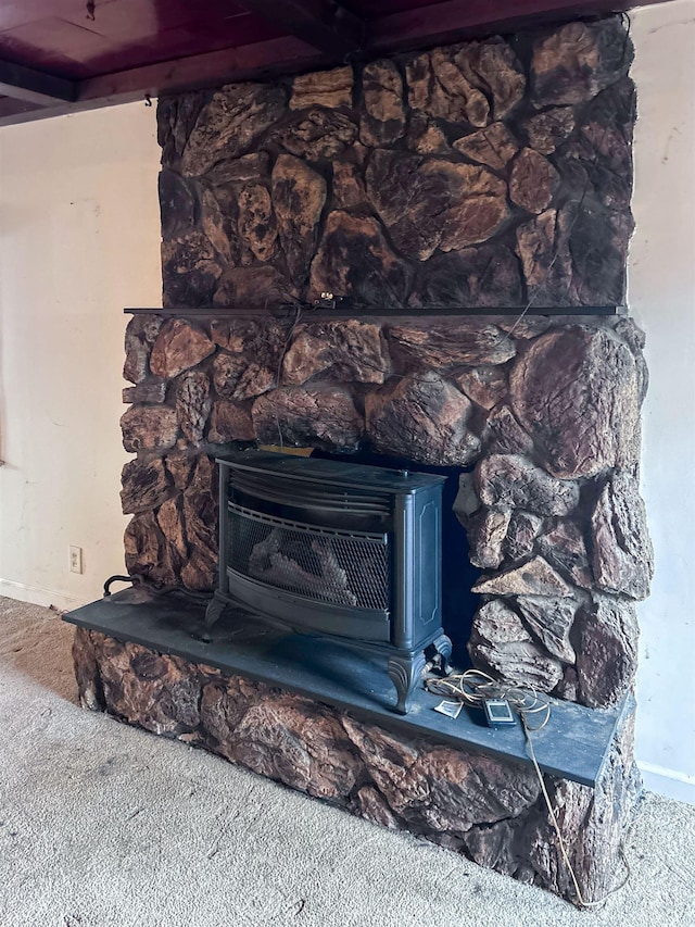 room details featuring carpet flooring and a stone fireplace