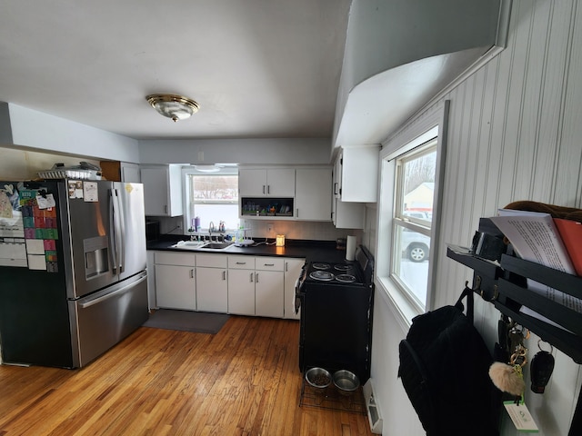 kitchen with white cabinetry, sink, a healthy amount of sunlight, and stainless steel refrigerator with ice dispenser