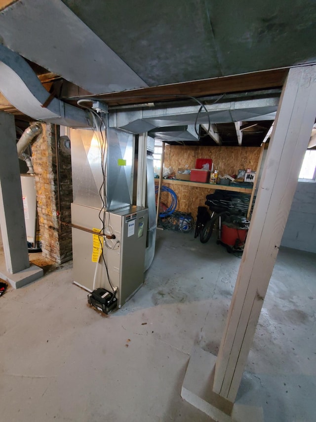 basement featuring heating unit and water heater