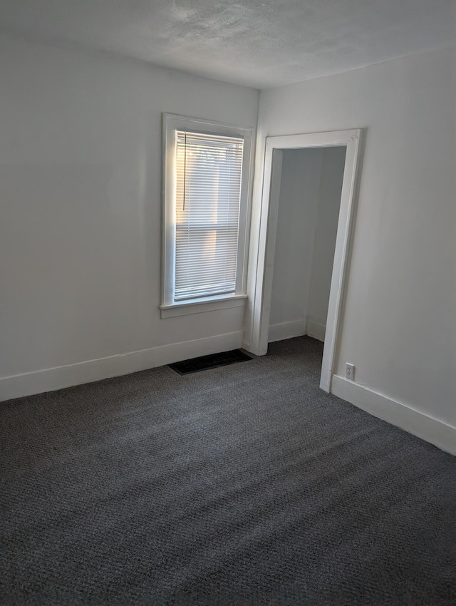 carpeted spare room featuring a textured ceiling