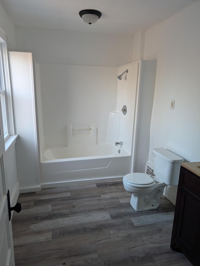 full bathroom with bathing tub / shower combination, vanity, wood-type flooring, and toilet