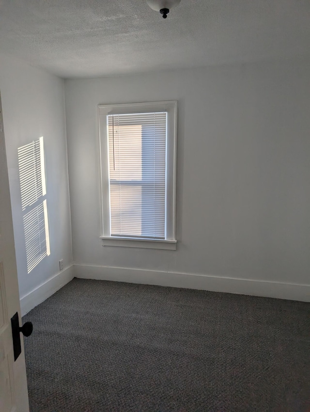 carpeted spare room featuring a textured ceiling