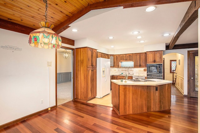 kitchen featuring black appliances, decorative backsplash, beam ceiling, decorative light fixtures, and a kitchen island