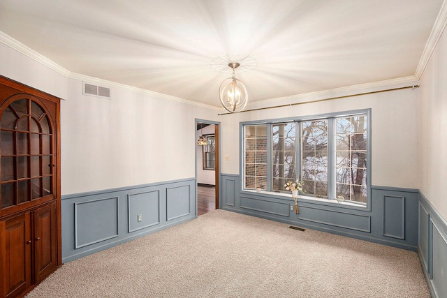 carpeted spare room featuring crown molding, a healthy amount of sunlight, and a notable chandelier