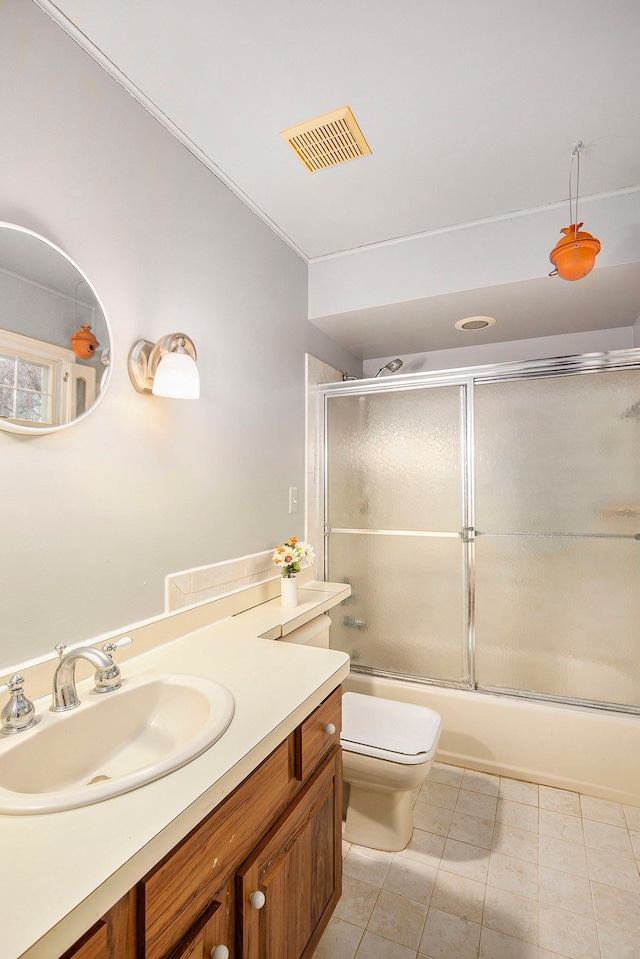 full bathroom with tile patterned floors, vanity, toilet, and shower / bath combination with glass door