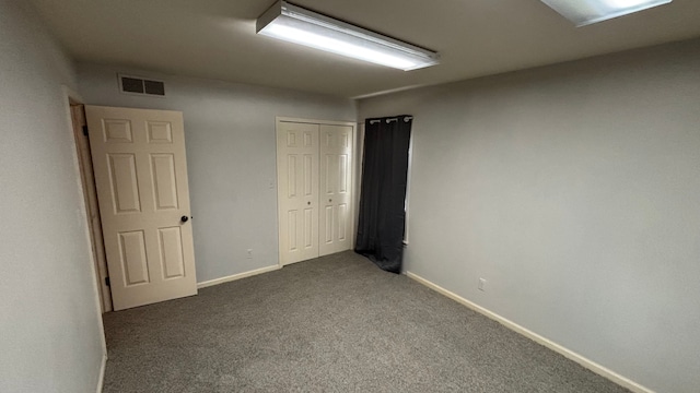 spare room with dark colored carpet