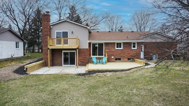 rear view of house featuring a balcony, a yard, and a patio