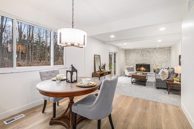 dining room with a fireplace and light hardwood / wood-style flooring