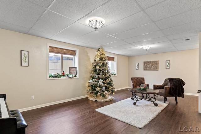 sitting room with dark hardwood / wood-style floors and a drop ceiling