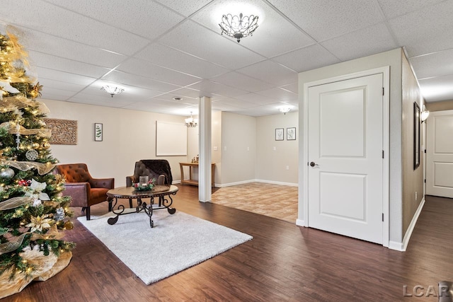 living room with a drop ceiling and dark hardwood / wood-style flooring