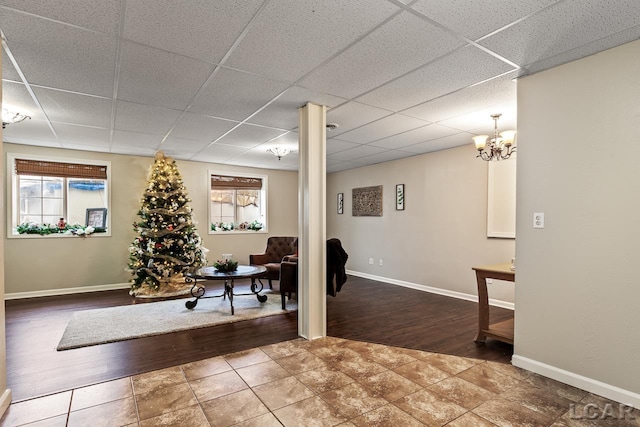 interior space featuring hardwood / wood-style flooring, a notable chandelier, and a paneled ceiling