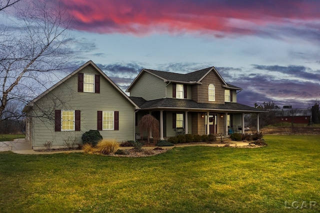 view of front of house featuring covered porch and a yard