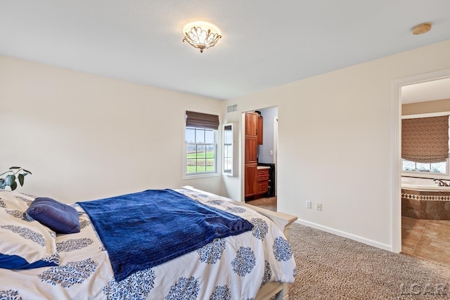 bedroom featuring ensuite bathroom and carpet