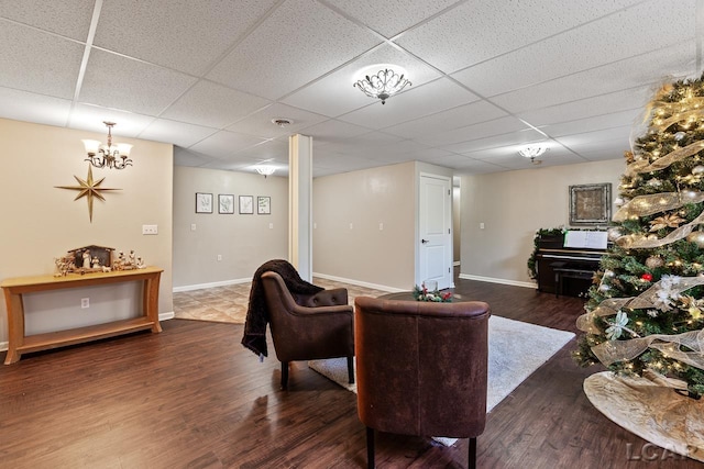 living room featuring dark hardwood / wood-style flooring and a drop ceiling