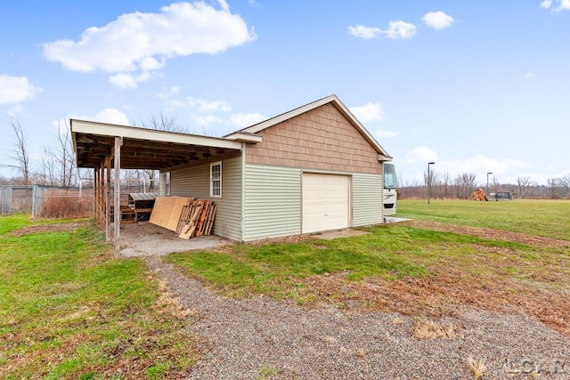 view of outdoor structure featuring a carport, a garage, and a yard