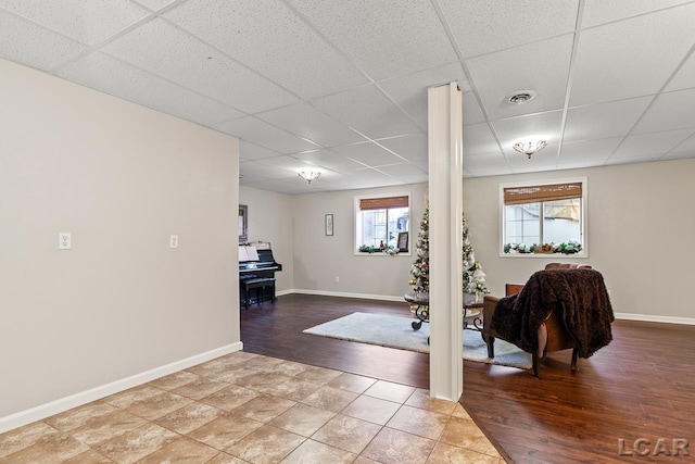 exercise area with hardwood / wood-style floors, a paneled ceiling, ornate columns, and a wealth of natural light