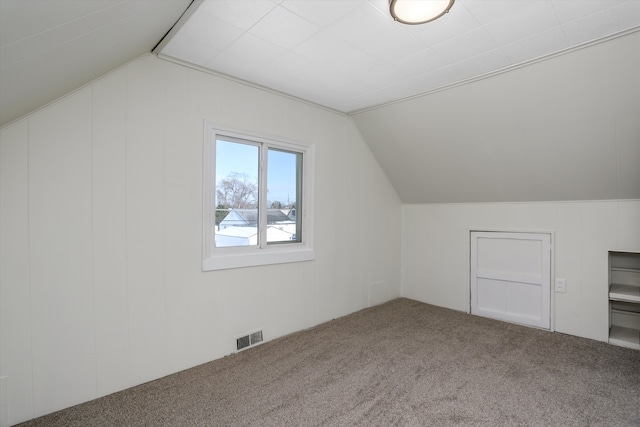 additional living space with carpet flooring and lofted ceiling