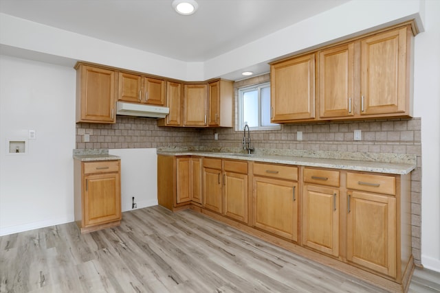 kitchen with decorative backsplash, light hardwood / wood-style flooring, and sink