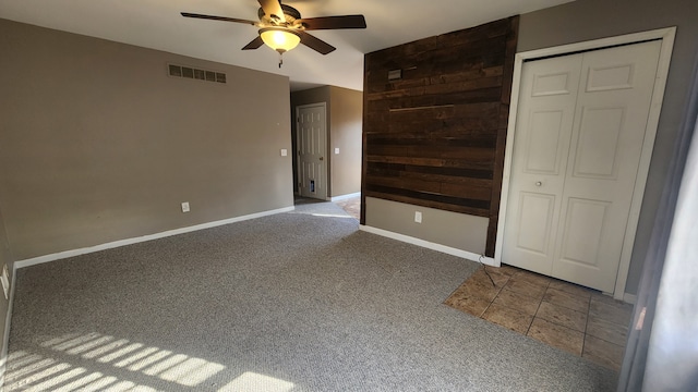 carpeted spare room with ceiling fan