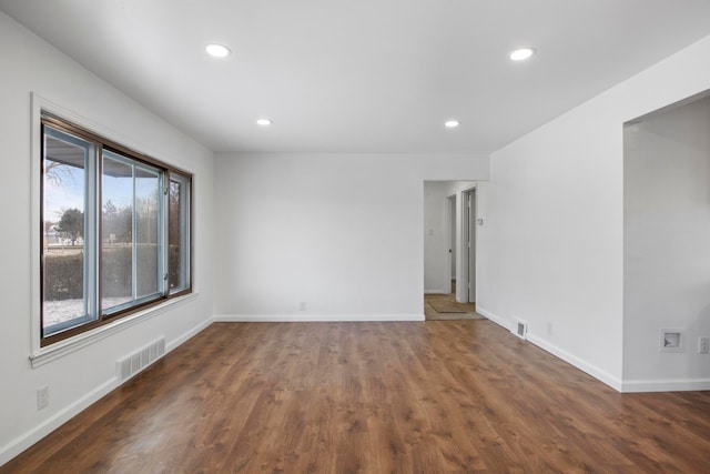 spare room with plenty of natural light and dark wood-type flooring