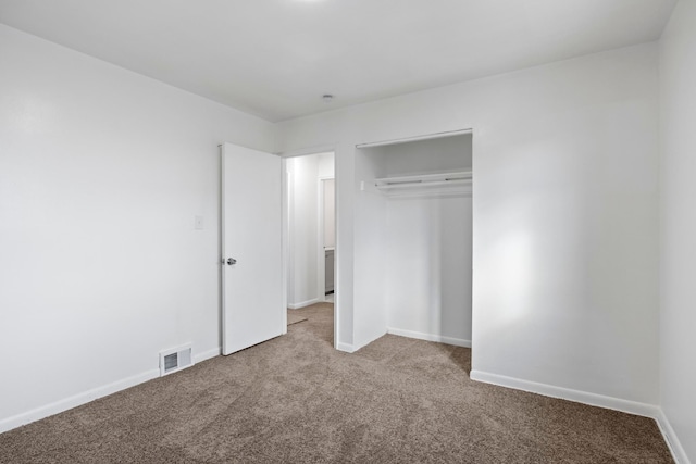 unfurnished bedroom featuring light colored carpet and a closet