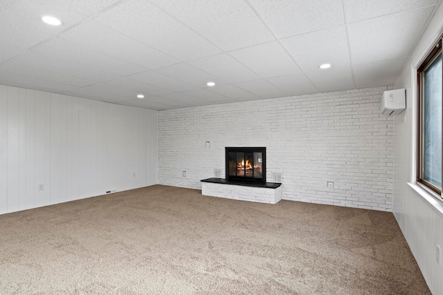 unfurnished living room featuring a wall mounted AC, carpet, and brick wall